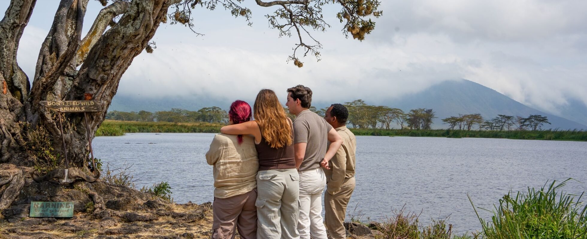Quatre personnes qui regardent la nature bras dessus bras dessous